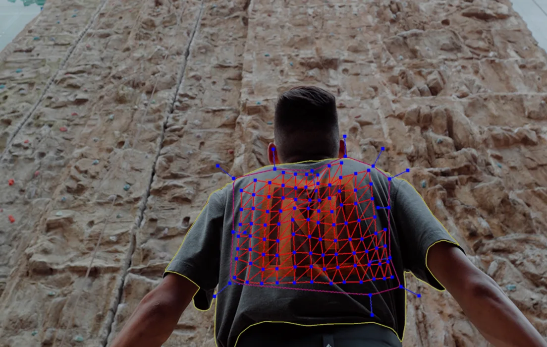Person facing a climbing wall with a Mocha Pro planar mesh tracking the large M printed on the back of their T-shirt